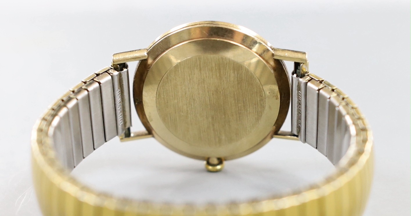 A gentleman's 1960' yellow metal Omega manual wind wrist watch, with date aperture, on associated flexible bracelet, no box or papers.